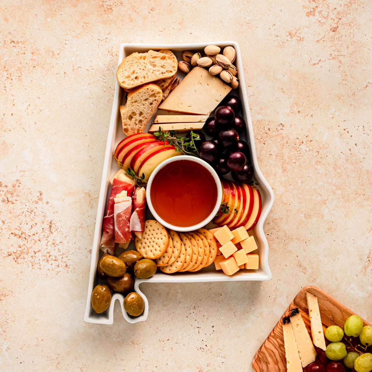 charcuterie board with cheese and cured meats in a alabama shaped serving tray