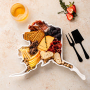 charcuterie board with cheese and cured meats in a alaska shaped serving tray