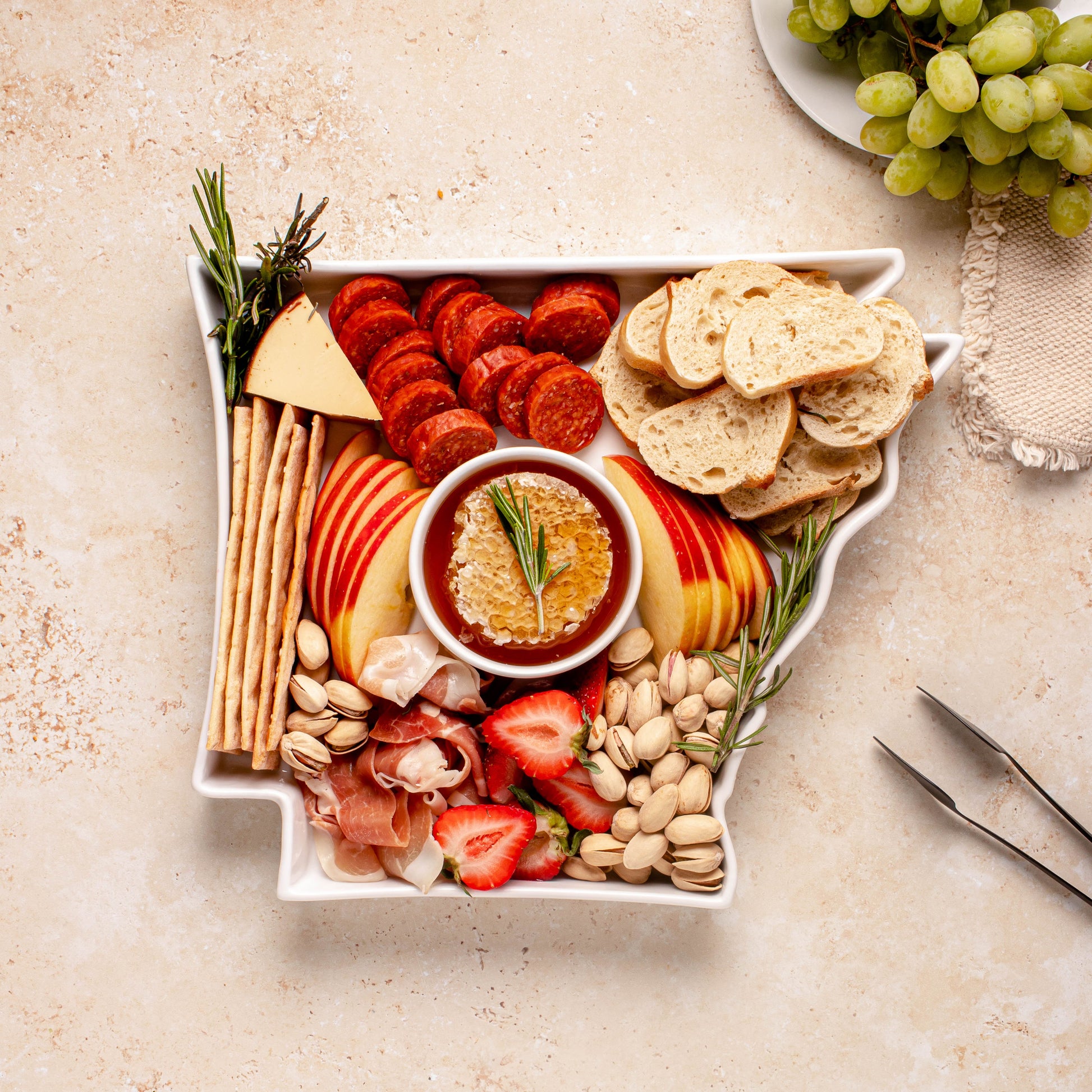 charcuterie board with cheese and cured meats in a arkansas shaped serving tray platter dish