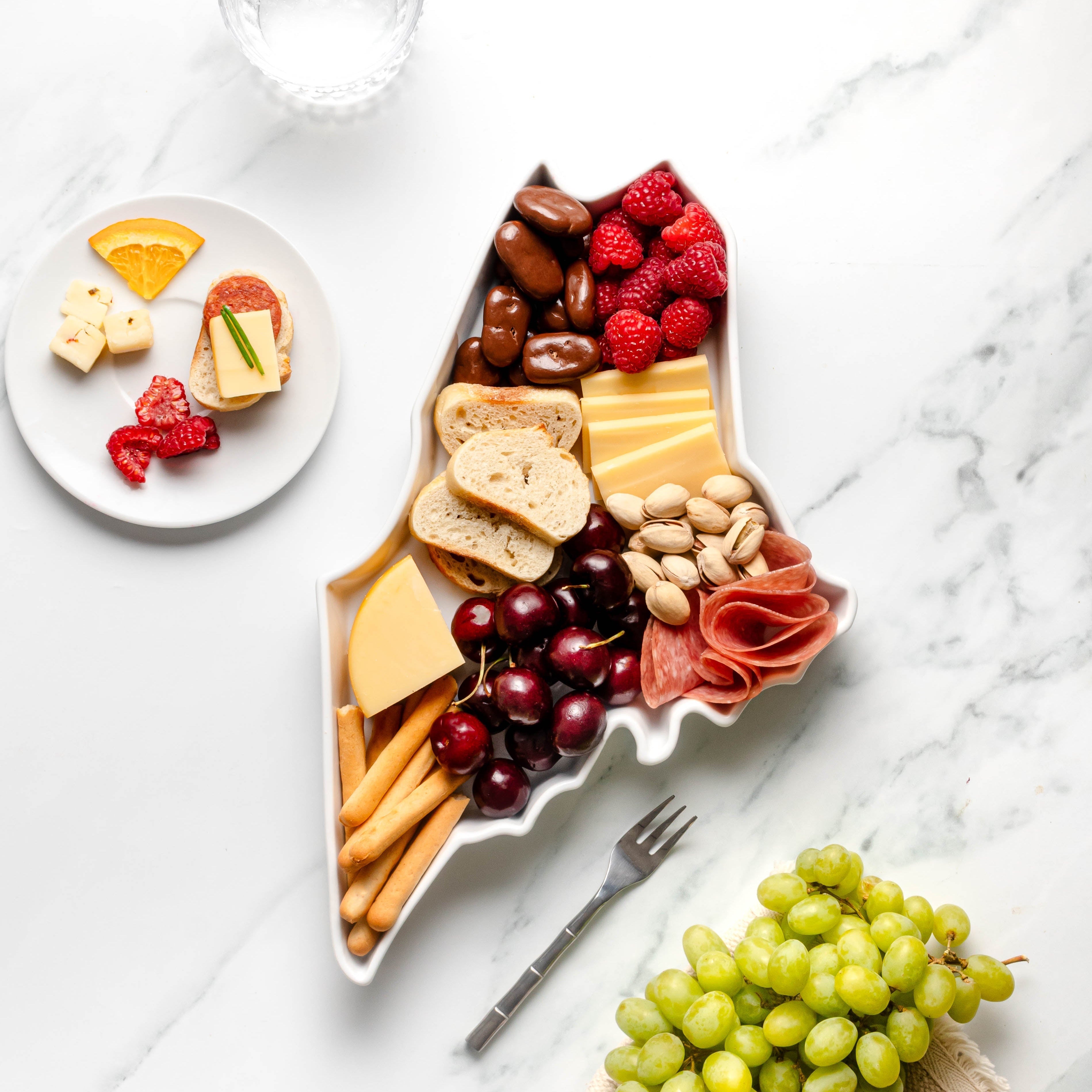 charcuterie board with cheese and cured meats in a Maine shaped serving tray platter dish