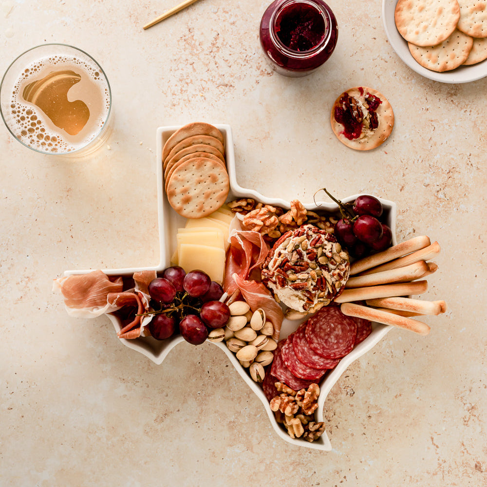 charcuterie board with cheese and cured meats in a Texas shaped serving tray platter dish